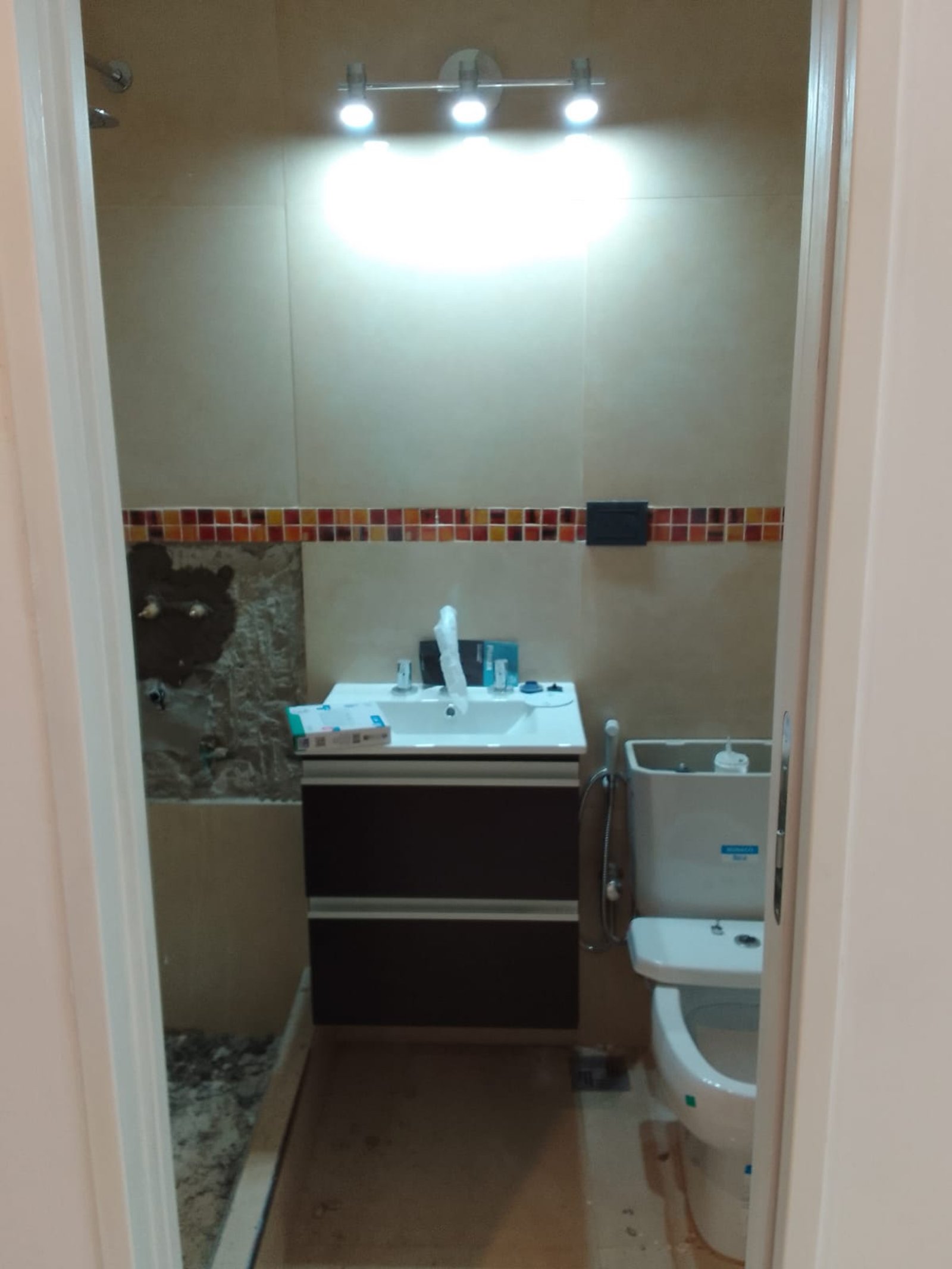baño moderno con vanitory, inodoro blanco y luces empotradas — proyecto Departamentos para turistas en Barracas, por Arquitecto Guido Niccoli, en Barracas